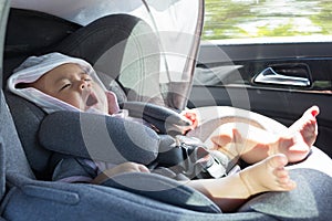 Close Up Asian cute newborn baby sitting in modern car seat.