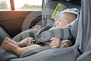 Close Up Asian cute newborn baby sleeping in modern car seat.