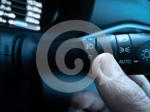 Close-up Asian hand (thumb), using turn on the high beam headlights.