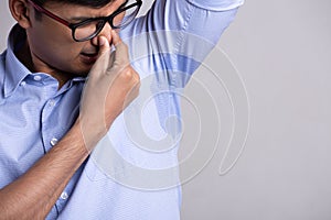 Close up asian man with hyperhidrosis sweating. Young asia man with sweat stain on his clothes against grey background. Healthcare