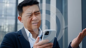 Close up Asian middle-aged adult man mad unhappy businessman feeling annoyed with using broken smart phone low battery
