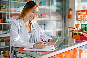 close up of asian pharmacist woman working writing drug list