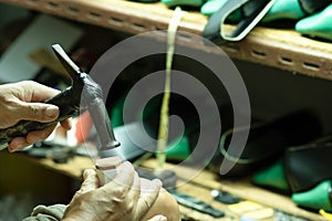 Close up Asian shoemaker hand repairing a woman shoe