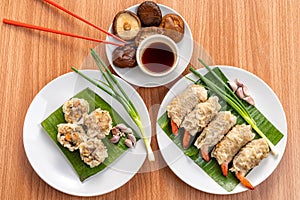 Close up Asian Steam  Dumplings  or Dim Sum a Famous Chinese Food  with Pork and Shrimp on Banana Leaf and White Dish on Wood
