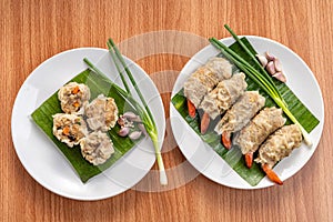 Close up Asian Steam  Dumplings  or Dim Sum a Famous Chinese Food  with Pork and Shrimp on Banana Leaf and White Dish on Wood