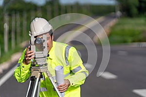 Close up of Asian surveyor engineer worker making measuring with theodolite on road works. survey engineer at road construction