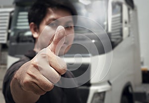 Close-up, Asian a truck driver giving thumb-up with semi truck.