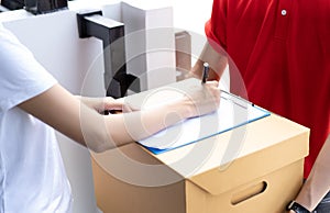 Close-up of a Asian woman appending signature sign on clipboard after accepting receive boxes from delivery man, woman sign on the