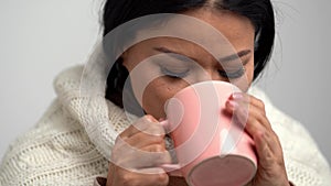Close up of Asian woman blowing on her beverage