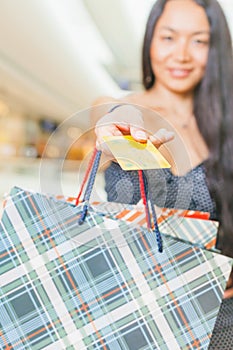 Close-up of asian woman's hand holding credit card and bags