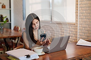 Close up, asian woman sitting on video call with friend on mobile phone, listened friend's voice through headphone