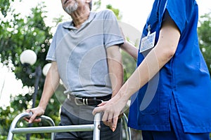 Close up of Asian young woman nurse visit and take care disabled senior elderly man. Caregiver doctor serve physical therapy for o