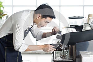 Close up of Asien barista man preparing coffee for customer in coffee shop photo