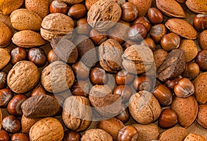 Close up of assortment nuts on a wooden table: wallnuts, almonds