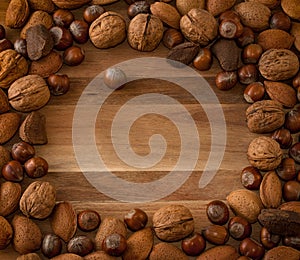 Close up of assortment nuts on a wooden table: wallnuts, almonds