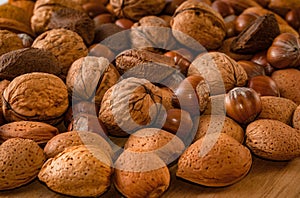 Close up of assortment nuts on a wooden table: wallnuts, almonds