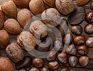 Close up of assortment nuts on a wooden table: wallnuts, almonds