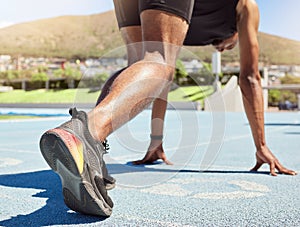 Close up of an athlete getting ready to run track and field with his feet on starting blocks ready to start sprinting