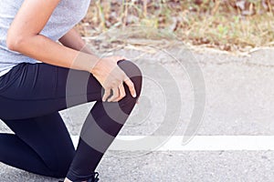 Close up Athlete running woman use hands hold on his knee while running in the morning.Knee injury on woman after traning for warm