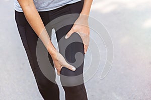 Close up Athlete running woman use hands hold on his knee while running in the morning.Knee injury on woman after traning for warm