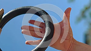 Close-up of an athlete\'s palms and hands grab grasping the olympic rings or gymnastics exercise using rings
