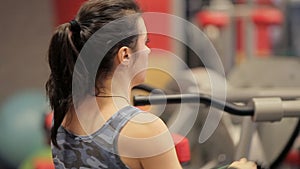 Close up of Athletic woman sweating taking a break after work out. The girl talks in the gym between trainings. The girl