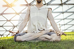 Close up of attractive athletic man practicing yoga and meditating outdoors.