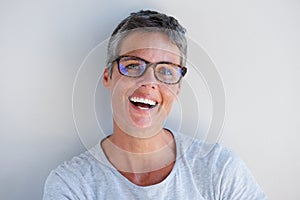 Close up attractive older woman smiling with glasses against white background