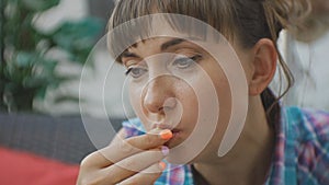 Close-up of attractive young caucasian woman eating tempura shrimp on open terrace of japanese restaurant.