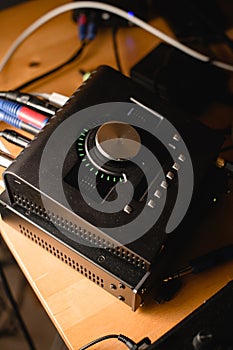 Close-up of an audio interface on a desktop with cables connected to other equipment