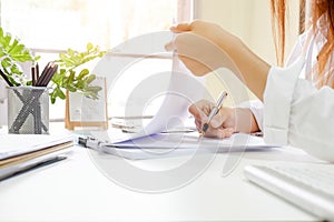 Close up audit woman calculate on paper document financial data.