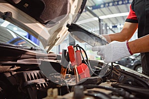 Close-up of an auto mechanic in a service center checking battery polarity and checking electrical system. car battery For