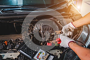 Close-up of an auto mechanic in a service center checking battery polarity and checking electrical system. car battery For