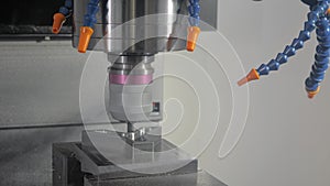 Close up - automated turning milling machine cutting metal workpiece at factory