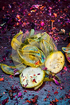 Close up of Ayurvedic face pack`s ingredients i.e  cucumber and Aloe Vera gel with rose petals on a wooden surface in dark Gothic