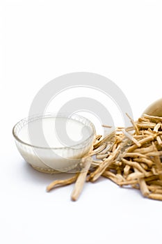 Close up of Ayurvedic herb Satavari or kurilo or Asparagus racemosus isolated on white in a glass bowl with milk.