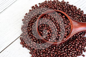 Close up of azuki beans in wooden scoop on white table background