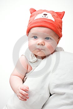 Close-up of babe in hat on light background. Handsome little boy