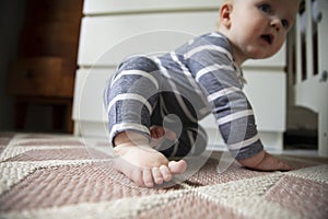 Close up of a babies foot and toes as they try to crawl on the floor