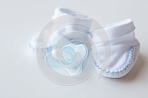 Close up of baby bootees and soother for newborn