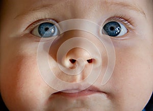 Close up of baby boy`s face with blue eyes