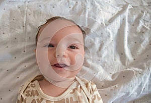 Close up of baby boy's face looking at camera with cute grin