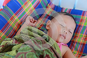 Close-up baby boy sleeping on bed with the blanket