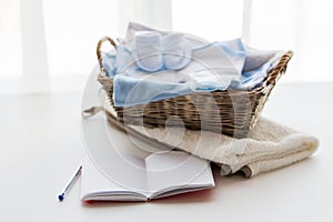 Close up of baby clothes for newborn and notebook