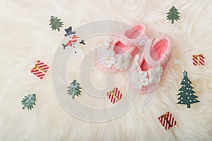 Close up Baby girl knitted shoes on white blanket background.Merry christmas and happy new year greeting card with copy-space.