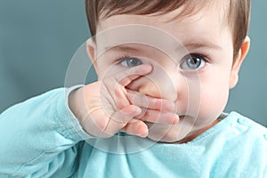 Close up of a baby girl looking at camera with a big blue eyes