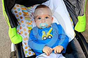 Close up of baby injury. Baby`s expression and the scar on the forehead after he hits his head on the ground. Baby in a stroller