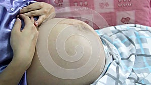 Close up baby movements during pregnancy. Baby moving inside mother`s womb.