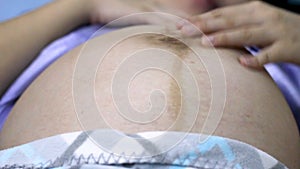 Close up baby movements during pregnancy. Baby moving inside mother`s womb.