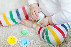 Close-up of baby playing playing with educational colorful shape sorter toy